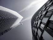 从低视角看现代摩天大楼的玻璃幕墙和晴朗的蓝天