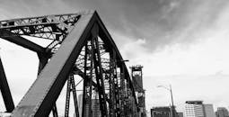 这张黑白照片展示了波特兰钢桥和城市天际线的建筑细节