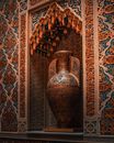 Interior of Real Casino de Murcia in Costa Blanca including multi colored Arabic script on wall and different ornaments composing with luxurious antique amphora in alcove