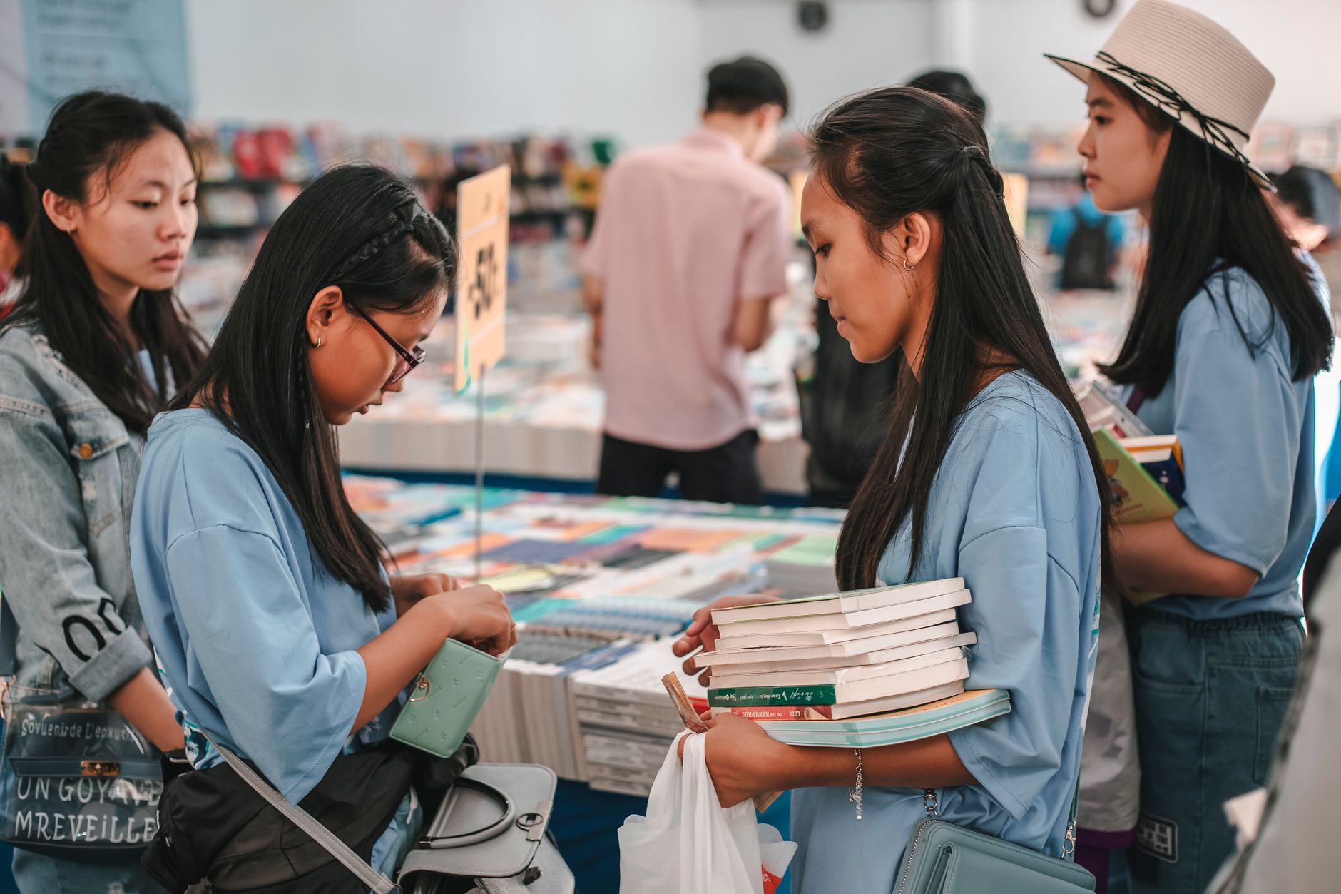 Students browsing and buying books in a busy bookstore environment.