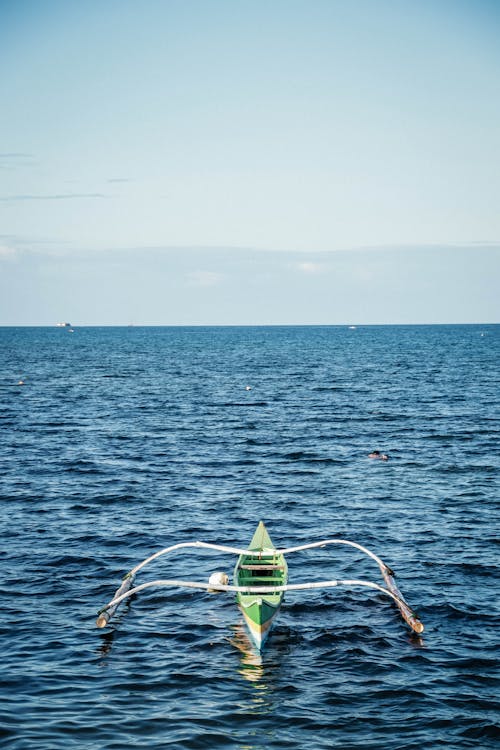 Green and White Boat on Body of Water