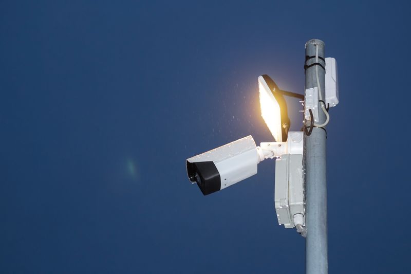 Security camera and floodlight on a pole at night