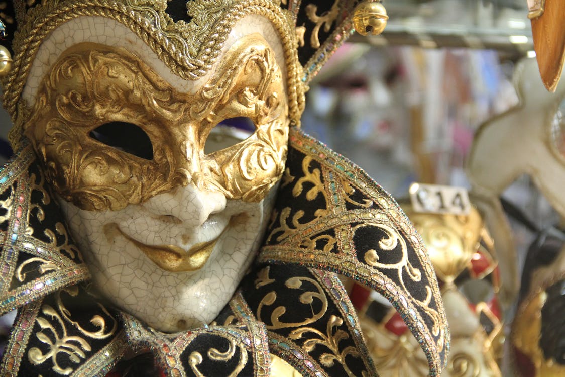 Free Closeup traditional elegant Venetian mask with golden ornaments hanging in vitrine of shop during carnival Stock Photo