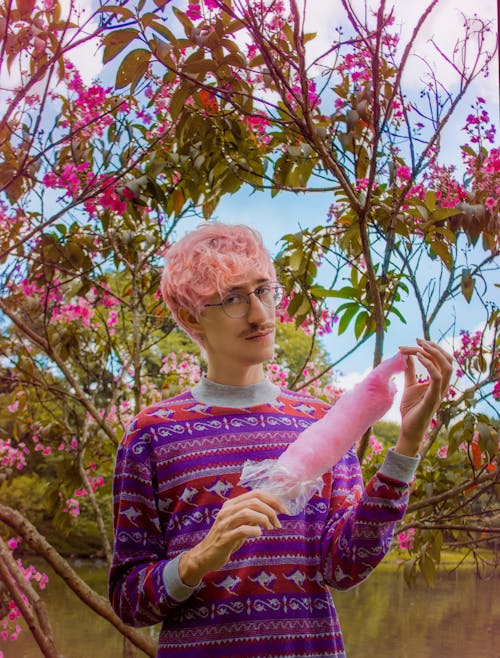 Free Man in Printed Top with Pink Hair Holding a Cotton Candy Stock Photo