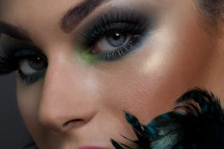 Closeup beautiful young woman with colorful eyeshadows and long eyelashes looking at camera