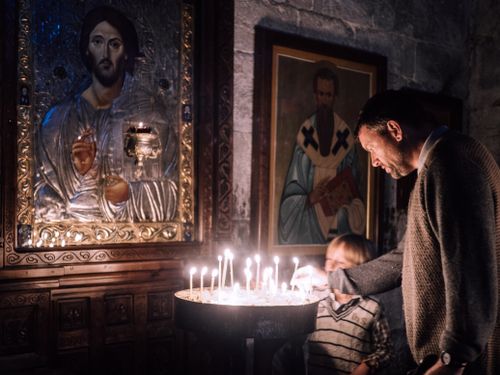 Free A father and son light candles in a church, symbolizing deep spirituality and prayer. Stock Photo