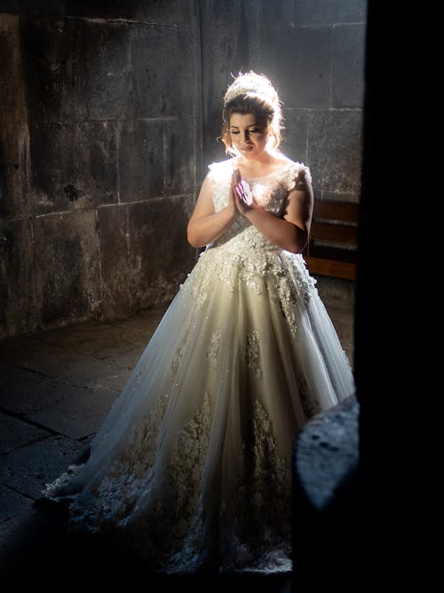 Woman in White Wedding Dress Standing Near Gray Concrete Wall