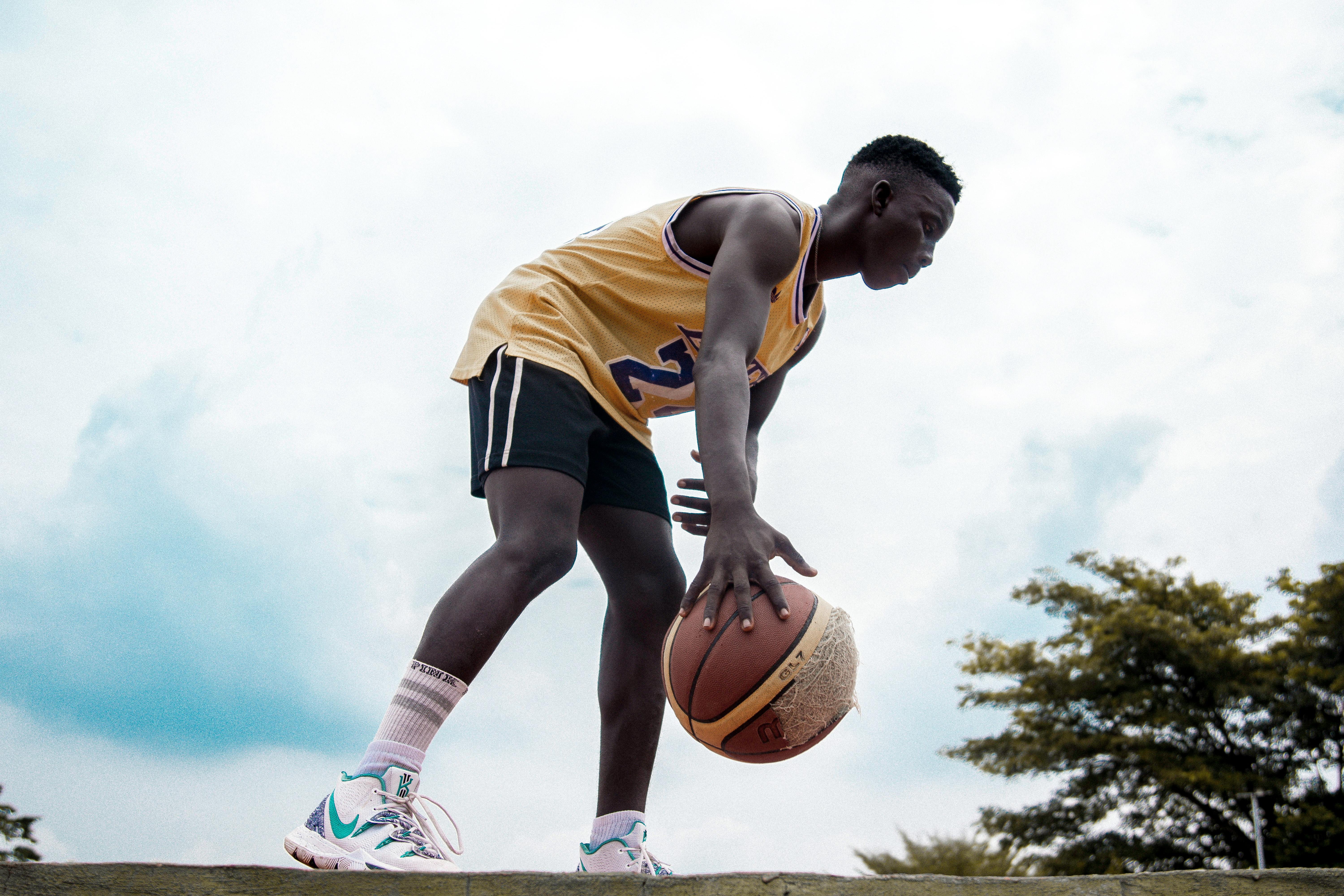 A little boy in panama, a yellow jersey, red shorts and white sneakers sits  on a yellow penny and holds a basketball multicolored ball, a soccer black  Stock Photo - Alamy