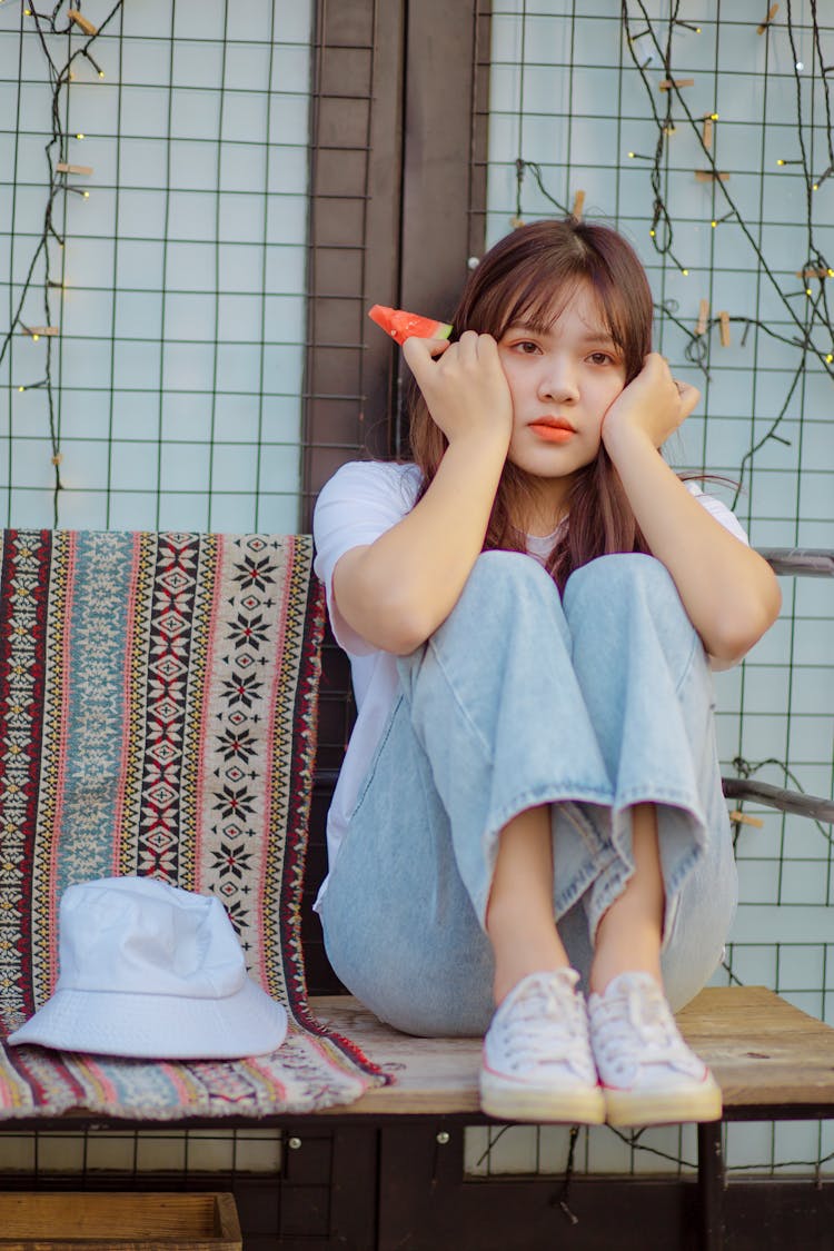 Sad Asian Female With Watermelon Sitting On Bench