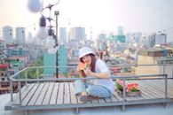 年轻女子在屋顶上，以城市天际线为背景，享用西瓜