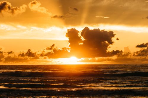 Free Sea waves rolling and splashing against orange cloudy sky with bright evening sky in nature Stock Photo