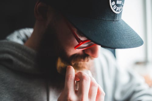 Stylish male hipster combing beard