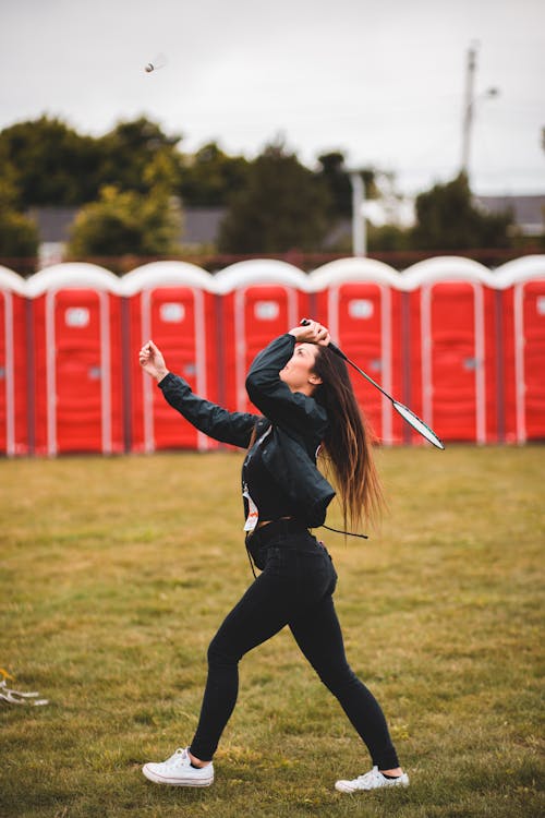 Woman in Black Jacket and Black Pants Playing Badminton