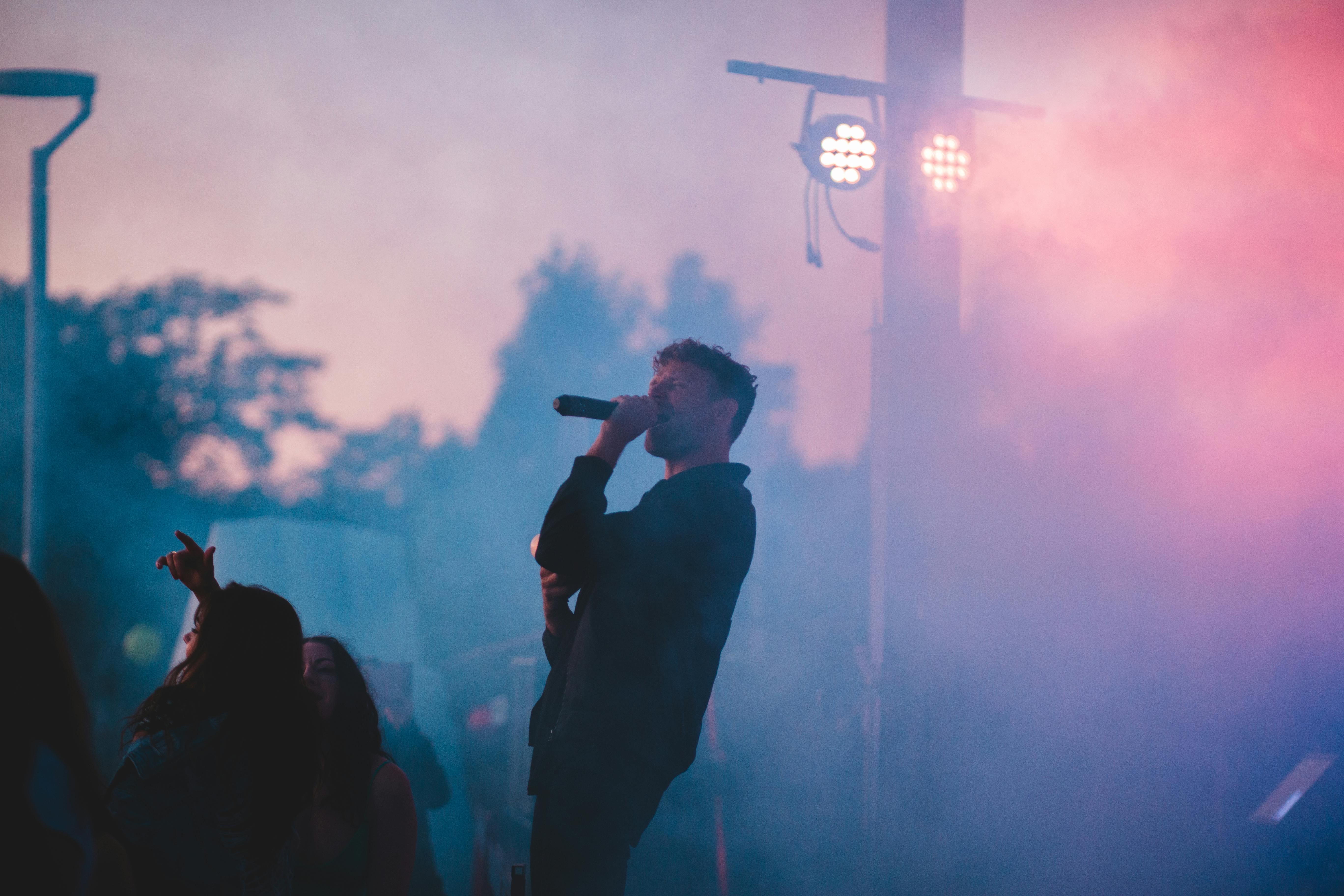 man in black jacket singing on stage