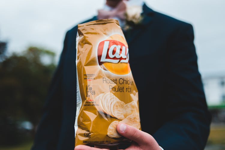 Unrecognizable Man With Bag Of Chips