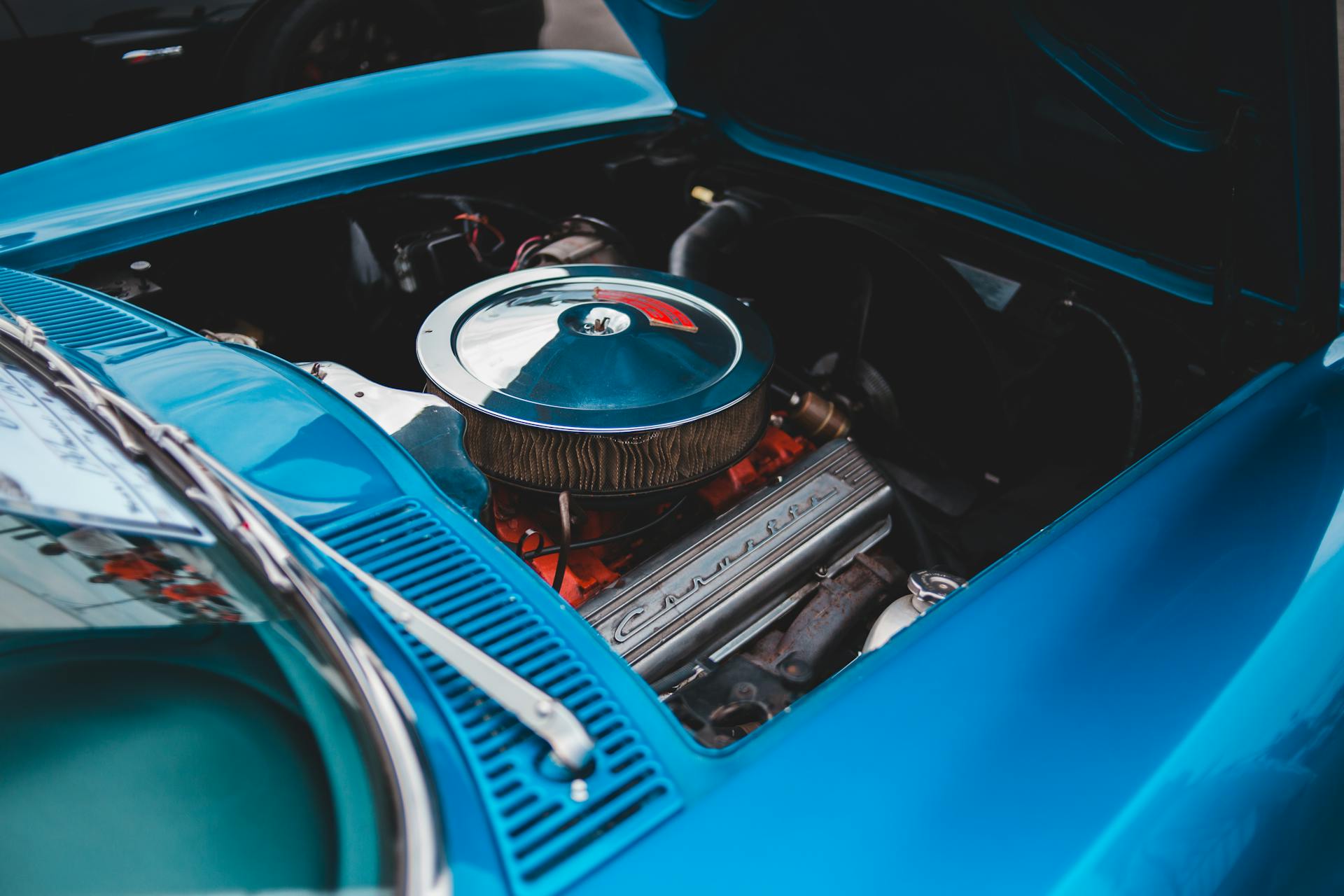 Close-up view of a classic car's engine compartment showing detailed components.