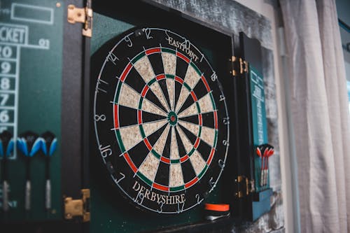 Round dartboard ready for game hanging on wall in cozy room at home