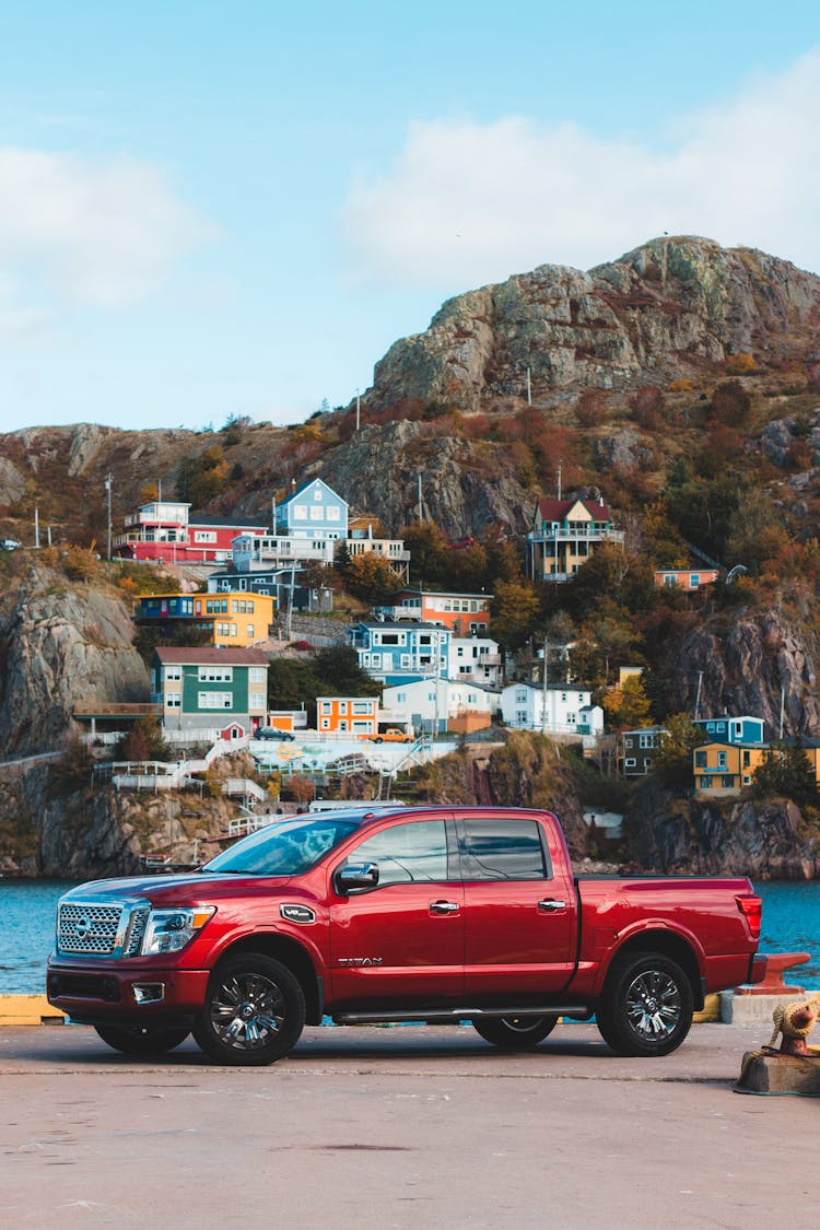 Red Crew Cab Pickup Truck Parked Near Brown Mountain