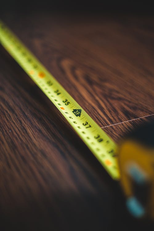 Yellow Measuring Tape on Brown Wooden Table
