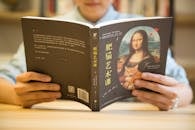 正在阅读一本“肥猫艺术”封面上有蒙娜丽莎和一只猫的书的人