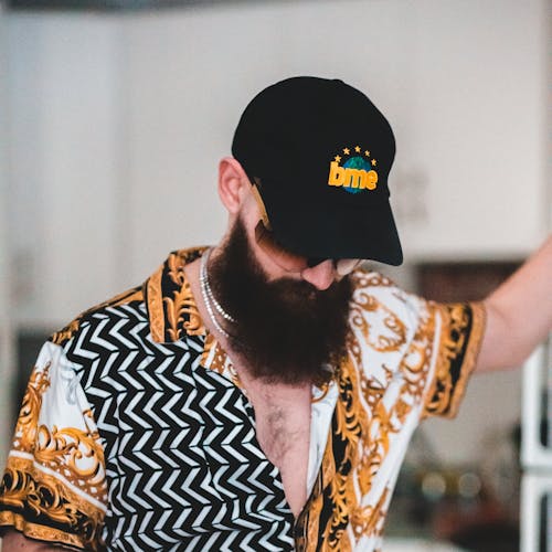 Man in Black and White Printed Shirt Wearing Black Cap