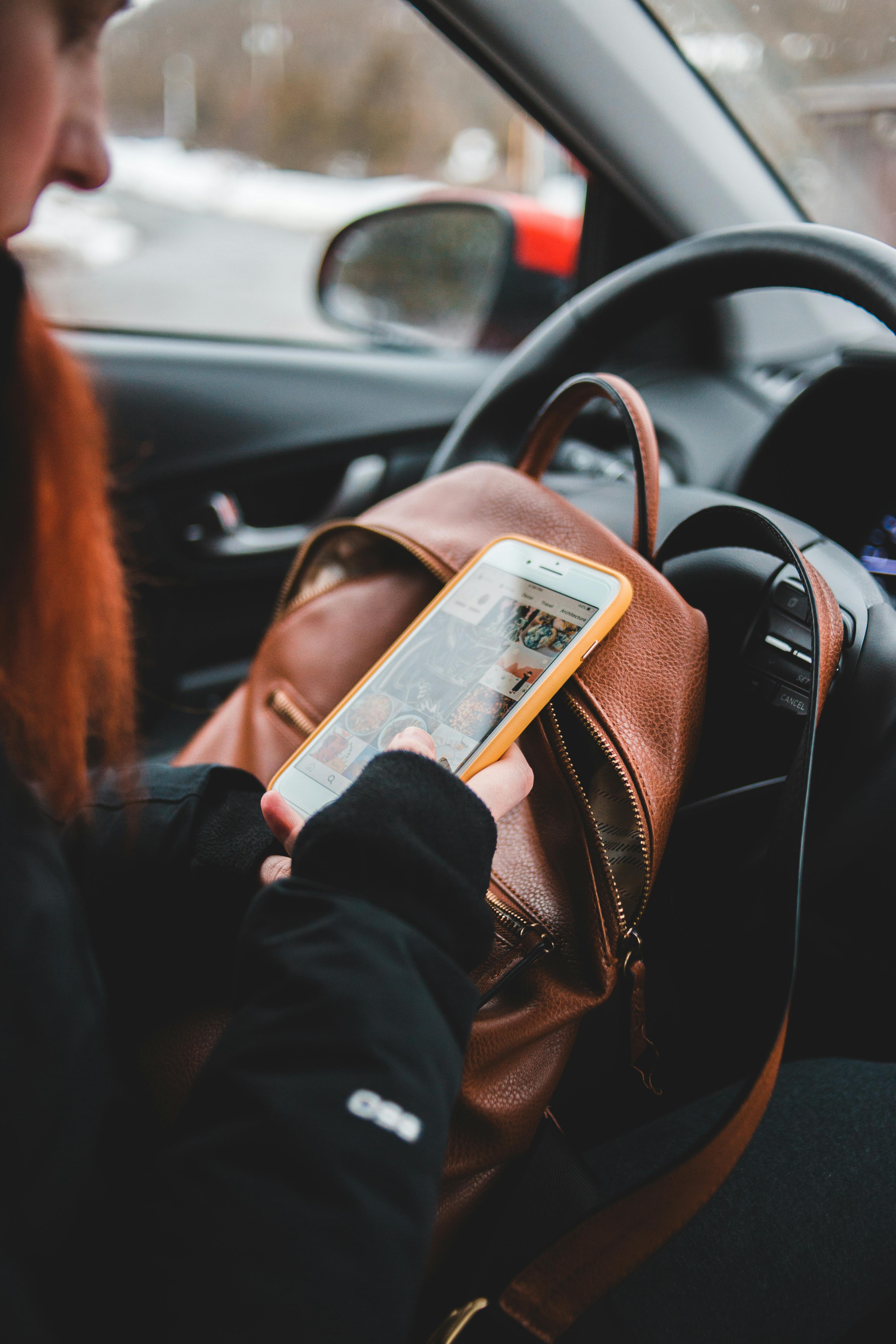 Female driver using smartphone in car · Free Stock Photo