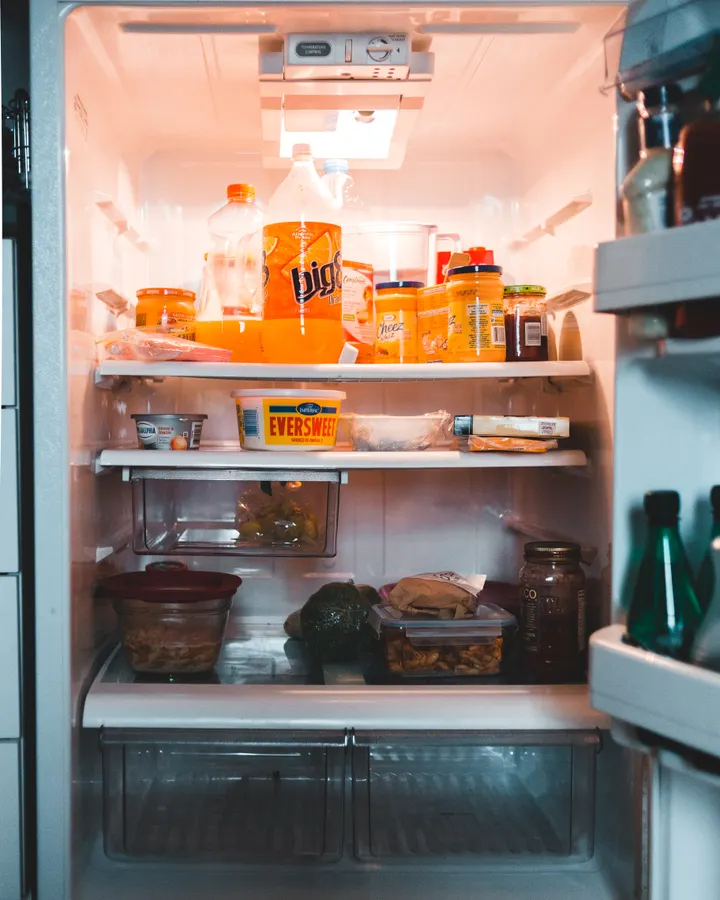 Defrost System Repair in La Mesa, CA Jars and food containers on refrigerator shelves in a fridge with a failed defrost system