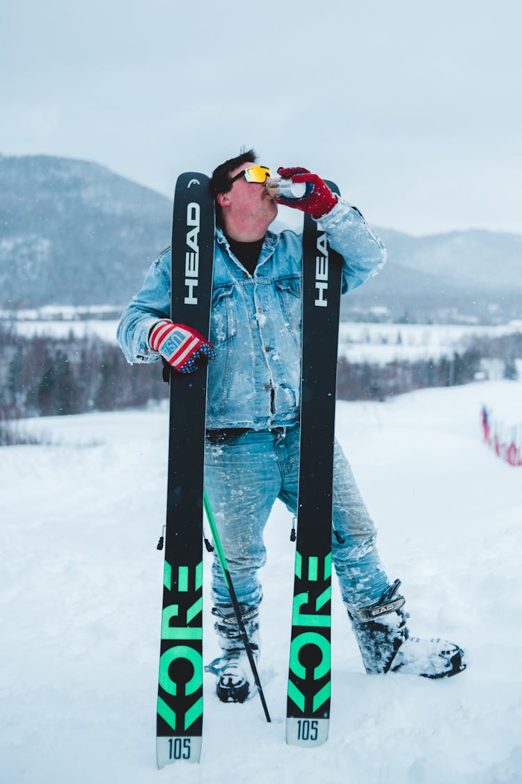 Skier Having Coffee On Mountain In Snowfall