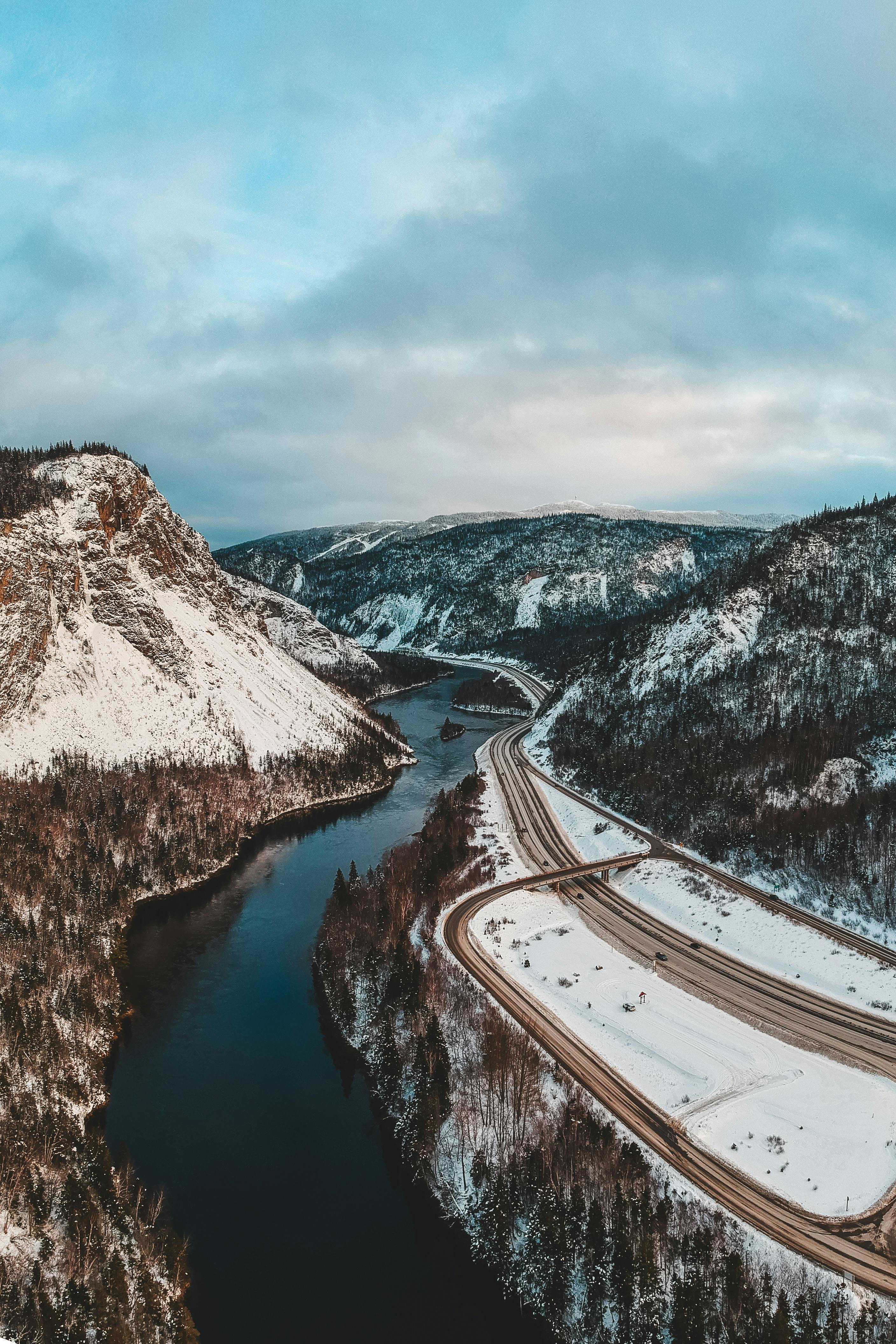 Free A breathtaking aerial view of snowy mountains and a winding river in Corner Brook, NL, Canada. Stock Photo