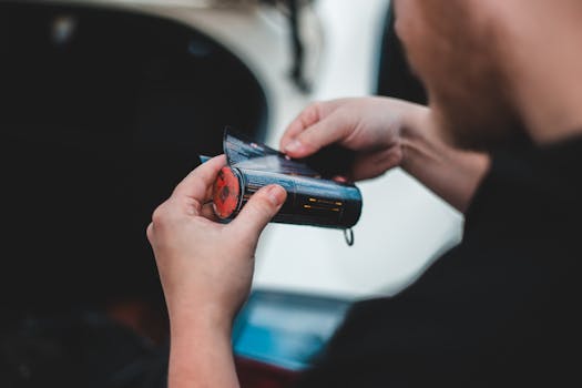 Person handling a roll of film in a blurred background setting. Focus on hands and film.