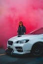 Unrecognizable man standing near modern car and bright dusty cloud
