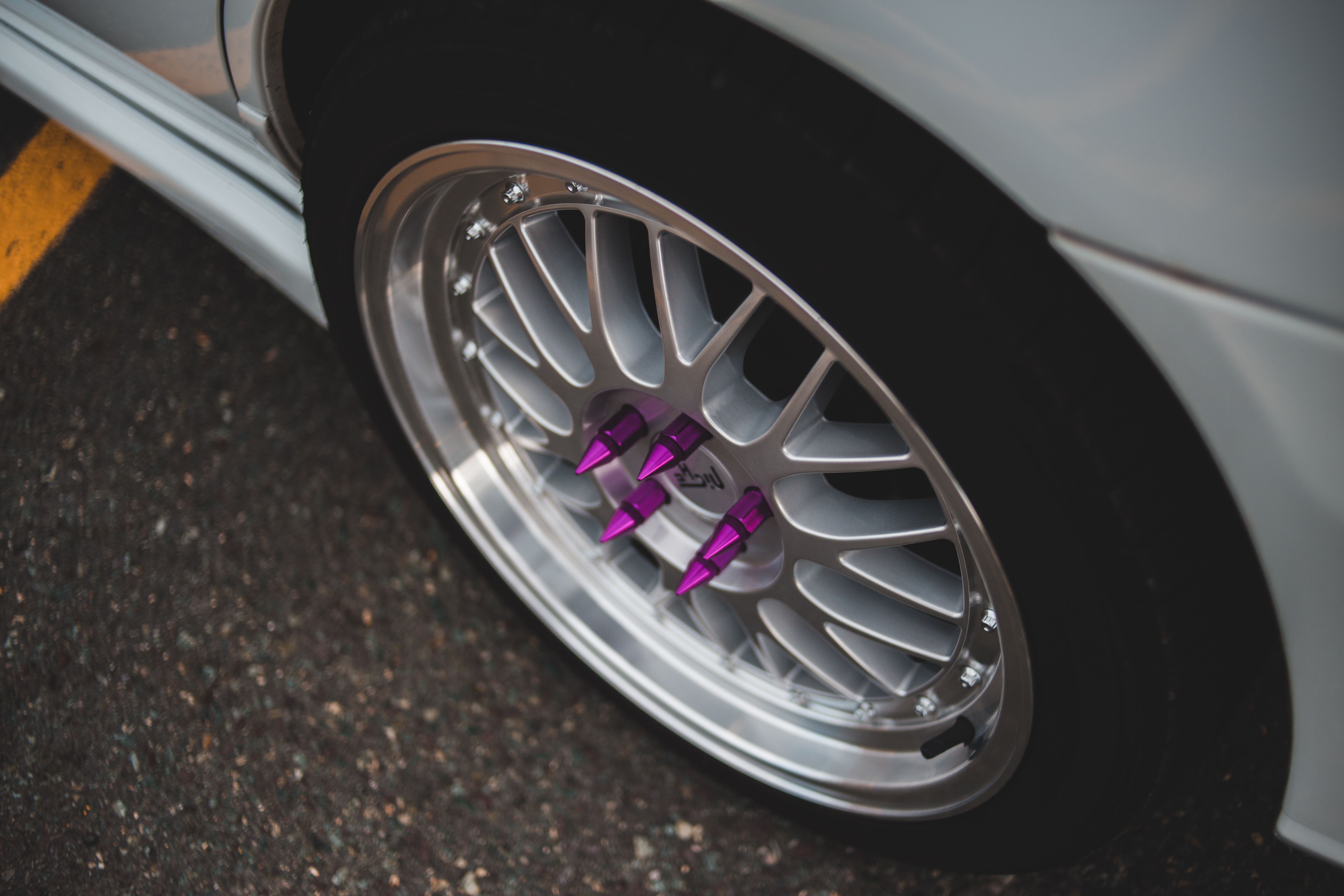 Modern car wheel with customised lug nuts · Free Stock Photo