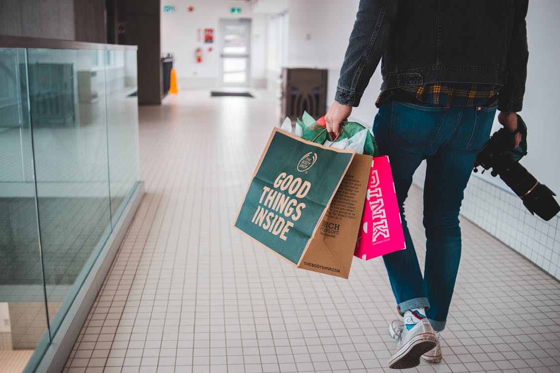 Free Person Holding Shopping Bags and Camera Stock Photo