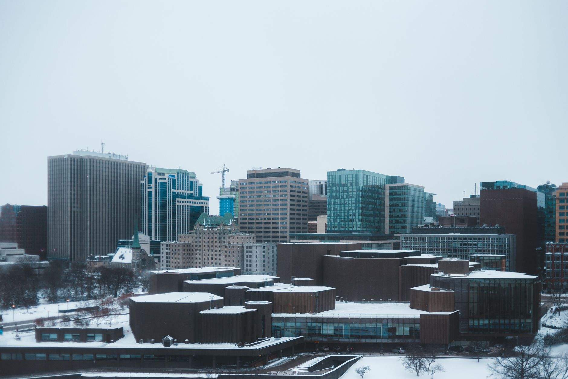 A cityscape view of a modern skyline with snow-covered buildings.