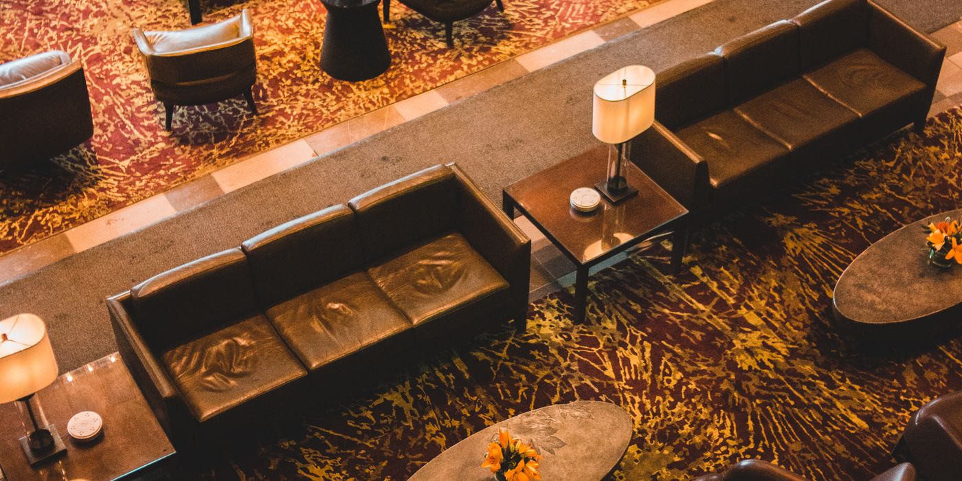 Modern hotel lobby with seating, plants and a check-in area