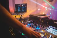 Dj with mixer controller in night club