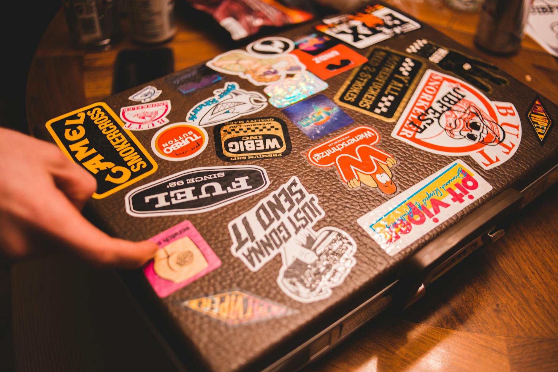 Black suitcase with stickers placed on table