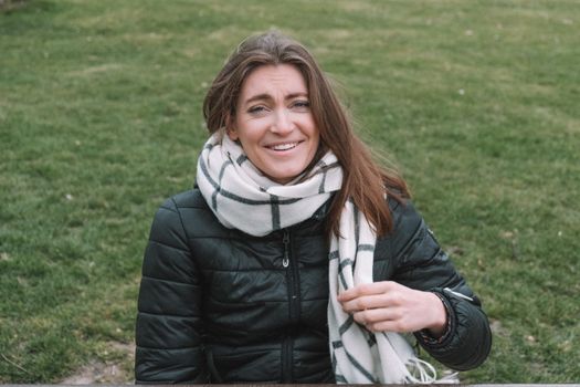 Woman in Black Leather Jacket Standing on Green Grass Field