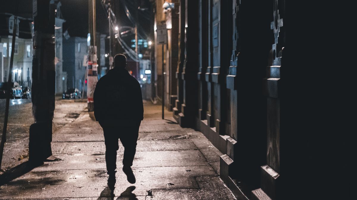 夜の街を歩く男性のシルエット(イメージ)