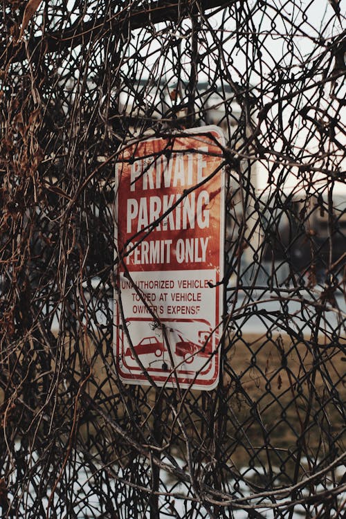 White and Red Sign Covered with Vines