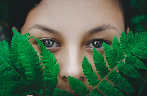 Close-Up Photo of Fern Leaves Near a Woman's Face