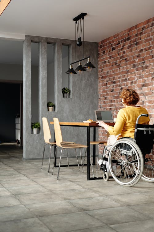 Woman in Wheelchair Using Laptop