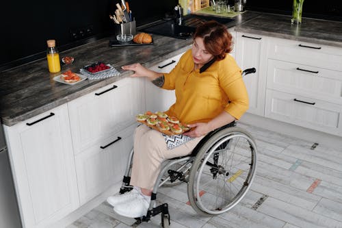 Woman in Wheelchair Using Phone in Kitchen