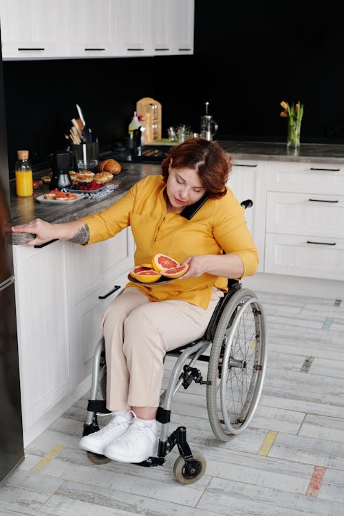 Woman in Yellow Long Sleeve Shirt Sitting on Wheelchair
