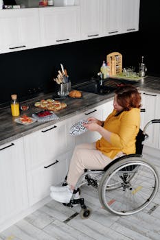 一位坐在轮椅上的妇女正在现代厨房里准备早餐