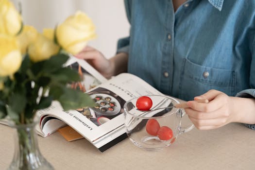 A woman enjoying a peaceful morning reading with cherry tomatoes and yellow flowers nearby.