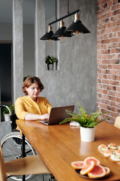 Woman in Yellow Long Sleeve Shirt Using Macbook