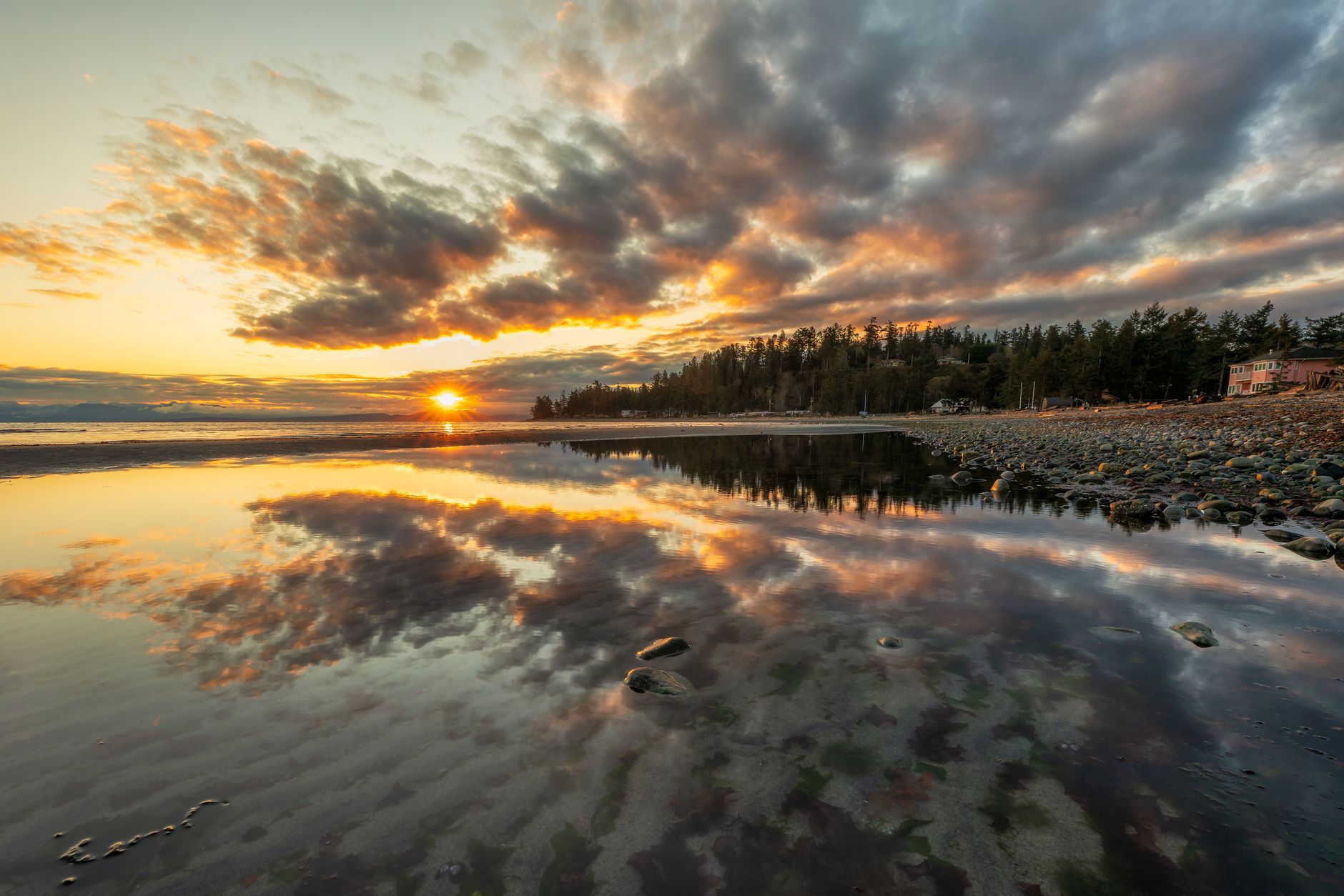 Capture the serene beauty of a dramatic sunset over Comox Beach, British Columbia.