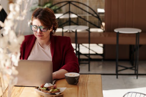 Woman in Red Blazer Using Laptop