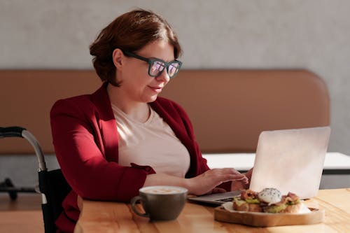 Photo of Woman Wearing Eyeglasses While Using Laptop